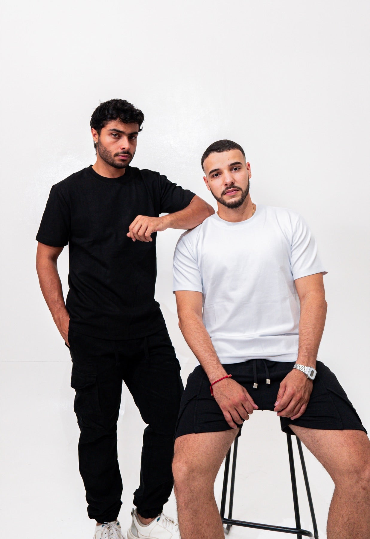 Dos modelos con camiseta basica Zenth negra y blanca en estudio